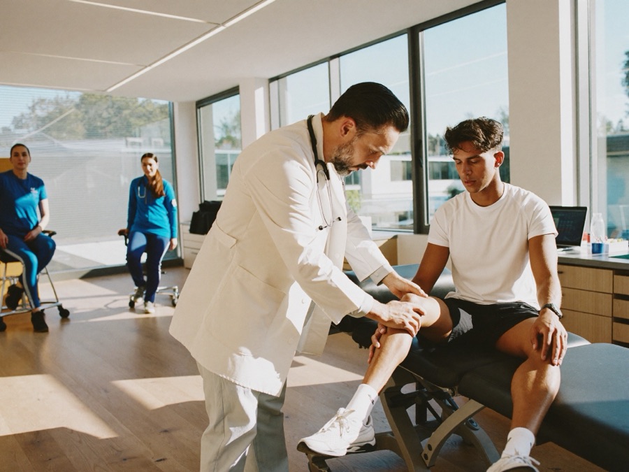 Sports medicine specialist examining an athlete's knee